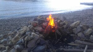 photo of a campfire by a lake